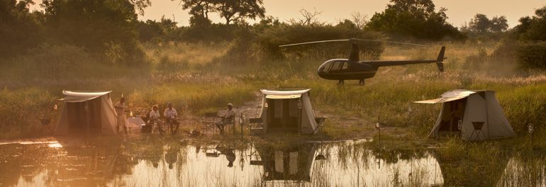 Selinda Adventure Trail Camp mit Safarizelten und Helikopter im Hintergrund