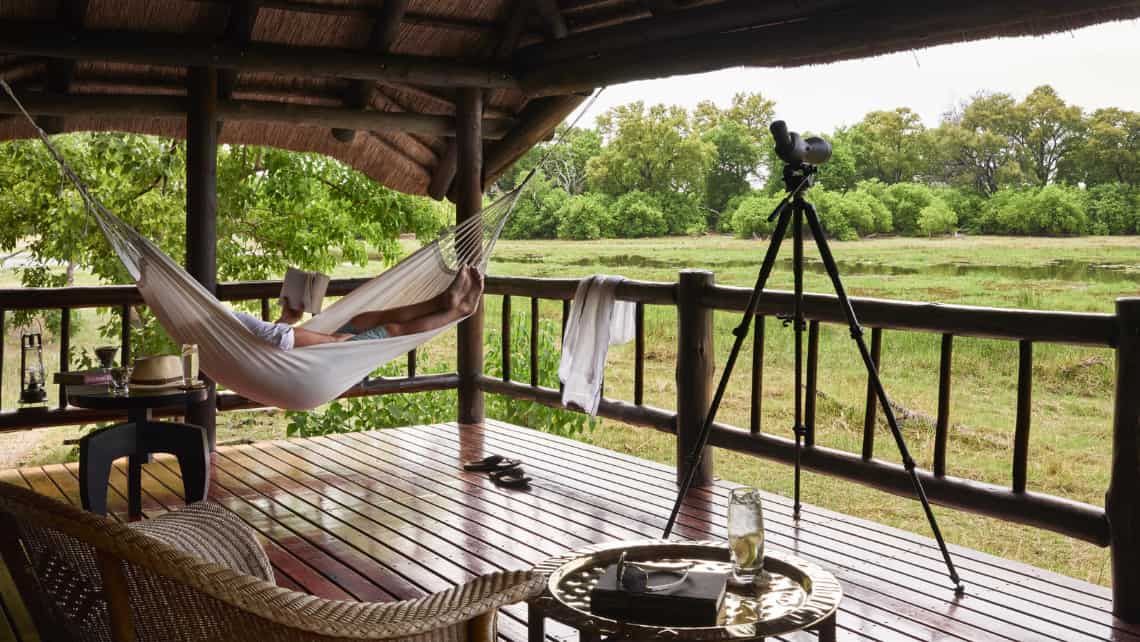 Terrasse  Luxuszelt mit Sessel, Hängematte und Blick auf die Lagune Belmond Khwai River Lodge, Khwai