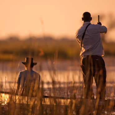 Privates Frühstück im Wasser einer Lagune vom Jao Camp im Okavango dlet ain Botswana mit Antilopen im Hintergrund